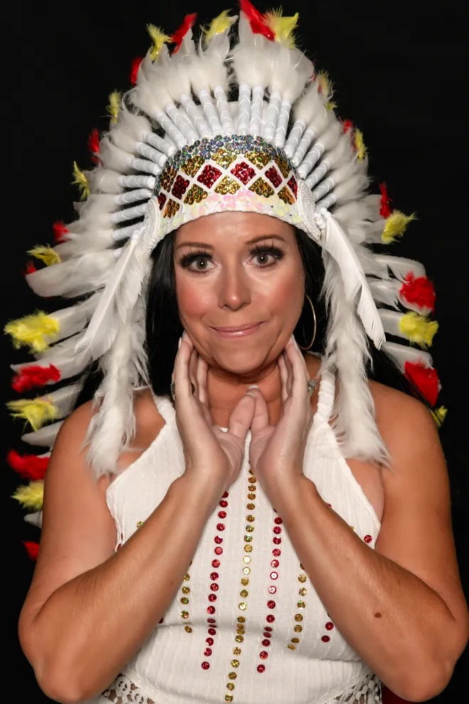 Studio portrait of Cher Alike in a white feathered headdress